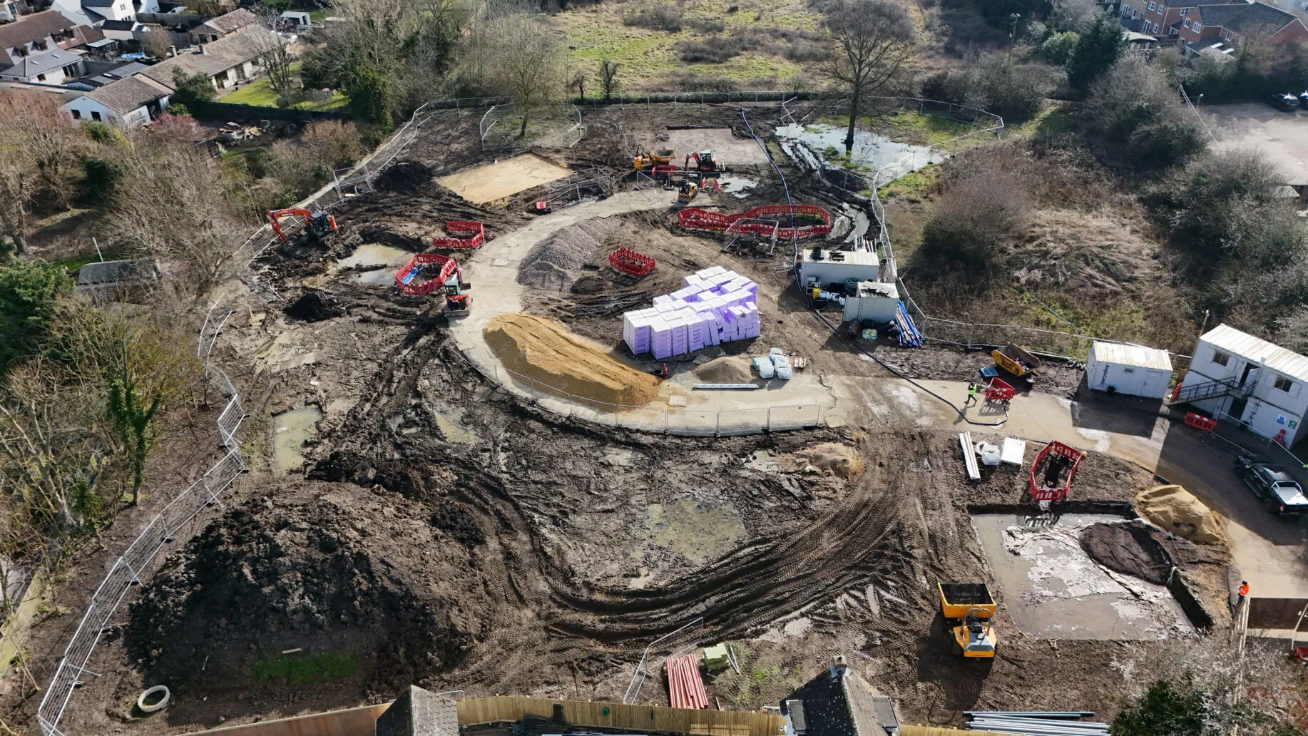 Construction project with equipment setup and ground works started.